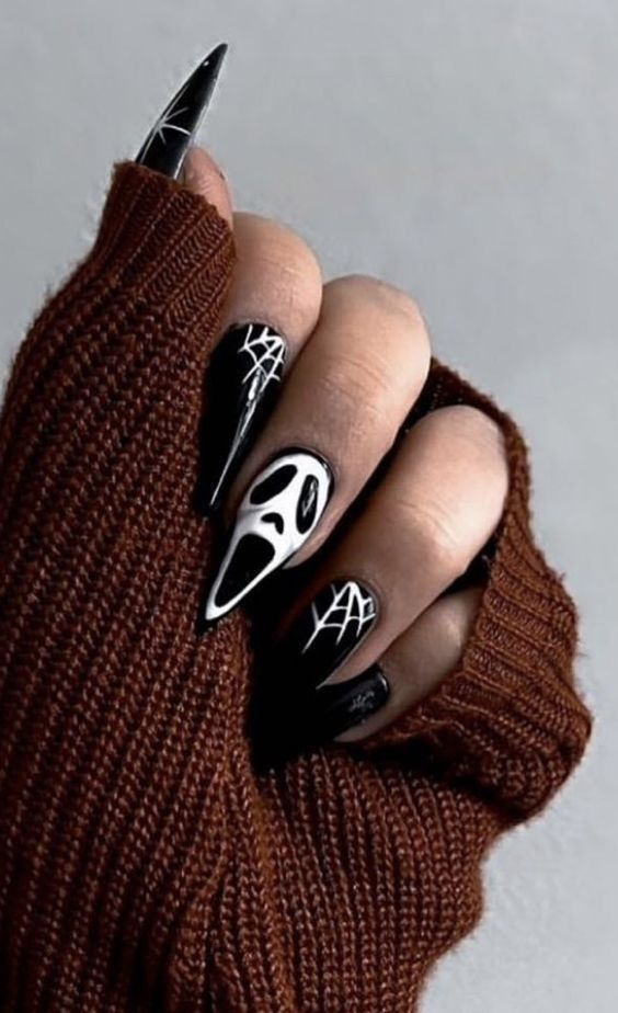 Black halloween nails with a scream face design