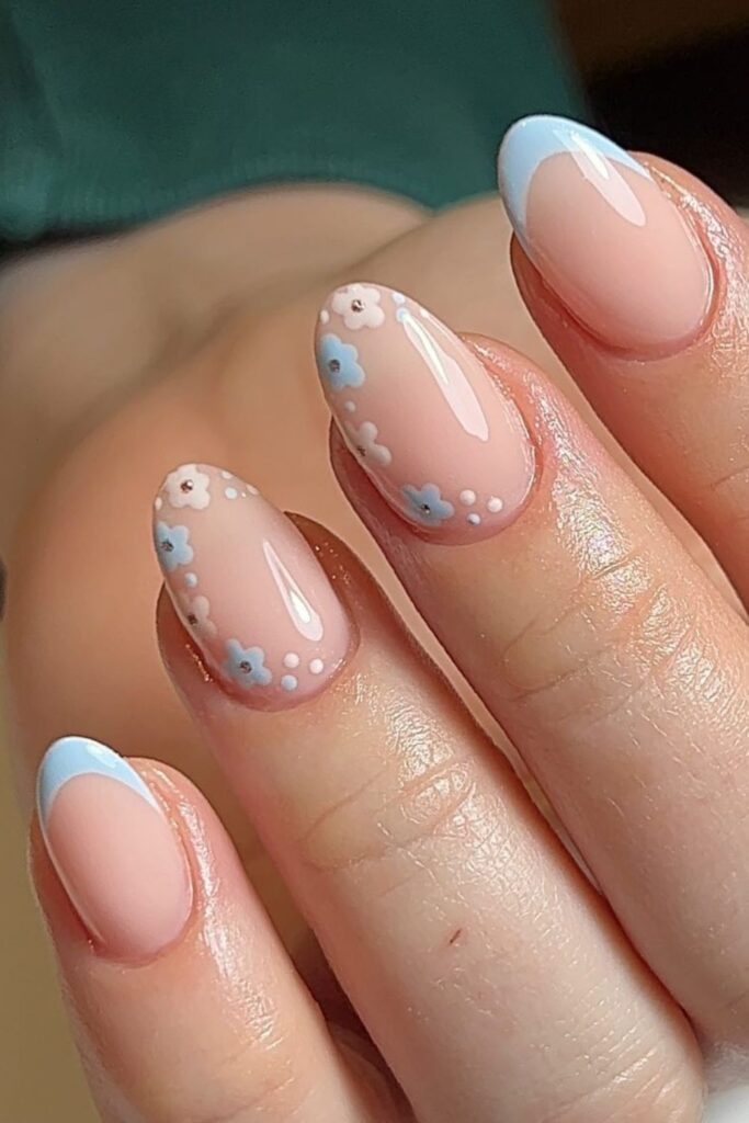 short spring nails with blue french tips and delicate floral nail art